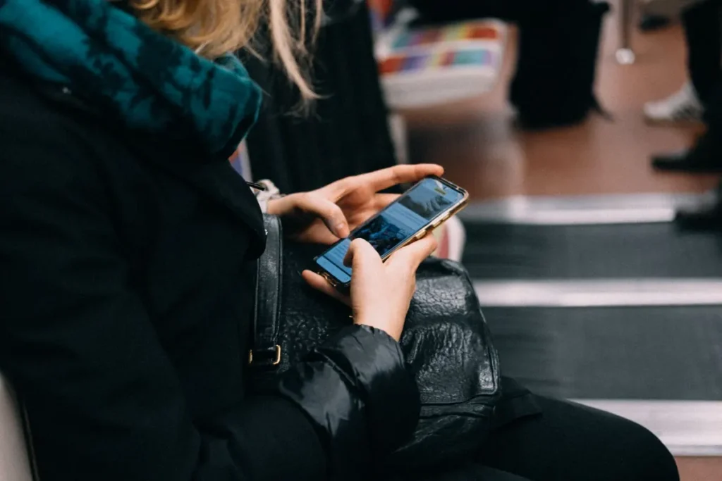 Žena používá telefon ve vlaku