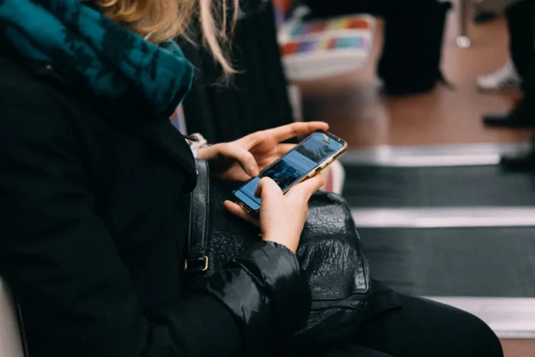 Žena používá telefon ve vlaku